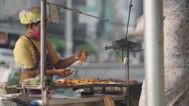 Tayland 'ın Bangkok şehrinde sokak yemekleri satan Asyalı bir kadın. orta ekran - 4K Yatay Görüntü