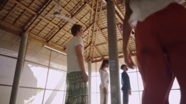 QiGong meditasyon oturumunda gerginlik ve negatif enerjiyi atmak için vücutlarını sallayan bir grup insan - 4K Yatay Video