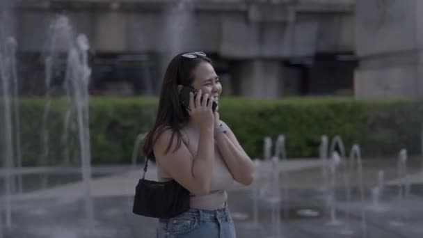Ázsiai Beszél Telefonon Nevet Áll Szökőkút Mellett Rengeteg Víz Városi — Stock videók