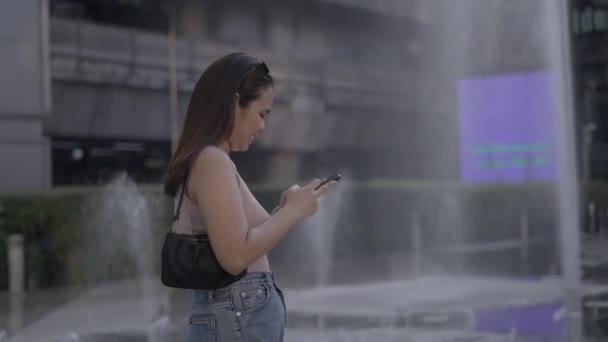 Nettes Asiatisches Model Das Mit Dem Smartphone Sms Schreibt Und — Stockvideo