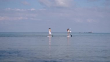 Tayland 'da Koh Phangan plajında sörf yapan tanınmayan bir çift. 4K yatay video.