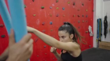 Güçlü bir kadın savunma sınıfında ağır çekimde ağır çekimde 4K yatay görüntü ile kendini savunma yumrukluyor.