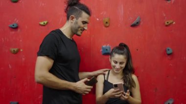 Kişisel antrenör ve müşterisi başarılı bir antrenman sonrası akıllı telefon kullanarak selfie çekiyorlar - 4K Yatay Video