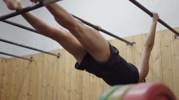ジムのスポーツバーで水平方向のプルアップを行う強力な女性 4K水平ビデオ — ストック動画