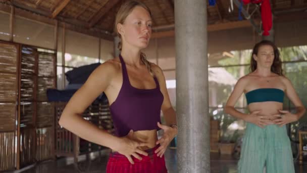 女性はタイのヒーリングセンターで瞑想クラスで呼吸や運動の演習に従事しています 4K水平ビデオ — ストック動画