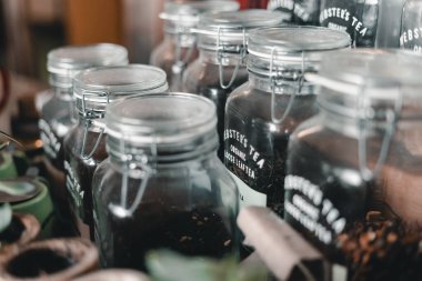 Bir rafa dizilmiş bir tel kapakla sıkıca kapatılmış çay dolu temiz ve temiz cam kavanozlar, Mylk barı, Yeni Zelanda - yaşam tarzı konsepti