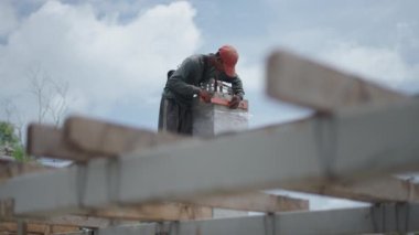 İnşaat alanındaki beton sütun seviyesini ölçen mavi yakalı işçi. düşük açı - 4K Yatay Görüntü