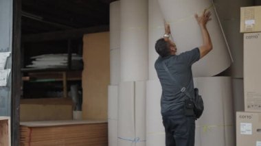 İşçiler Bangkok, Tayland 'da sevkiyat için karton rulo yükleme - 4K yatay video takibi
