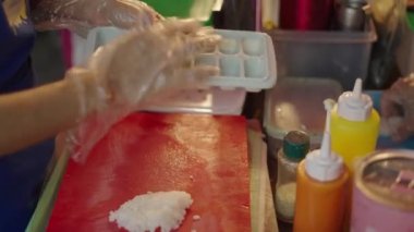 Kadının elleri Tayland pazarında suşi için buz tepsisine pirinç koyuyor - 4K Yatay video