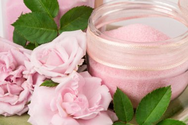 Beyaz arkaplanda yalıtılmış deniz tuzu ve gül özlü cilt fırçala.