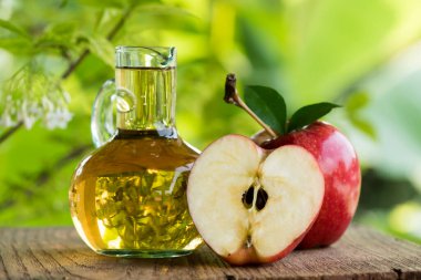 Elma meyvesi ve elma sirkesi doğa arka planında. 