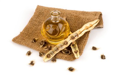 Moringa tohumları ve yağı beyaz arkaplanda izole edilmiş..