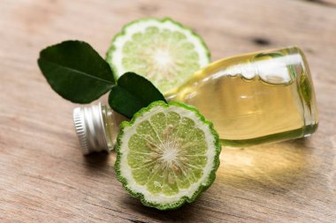 Eski bir ahşap arka planda Kaffir kireç veya sülük kireç meyvesi ve yağ.