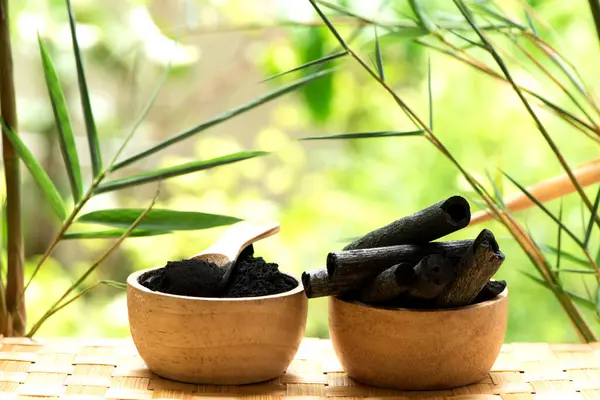 Bambu kömürü, yeşil yapraklar ve doğa arka planında izole edilmiş toz.