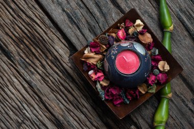 Kurumuş çiçeklerle ve eski bir ahşap arka planda mumla Aromaterapi.