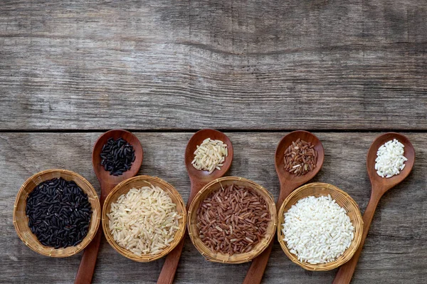 Rice,riceberry,jasmine brown rice ,jasmine red brown rice on an old wooden background.top view,flat lay.