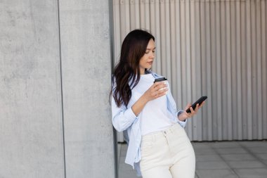 Açık havada cep telefonu kullanan esmer bir kadın.