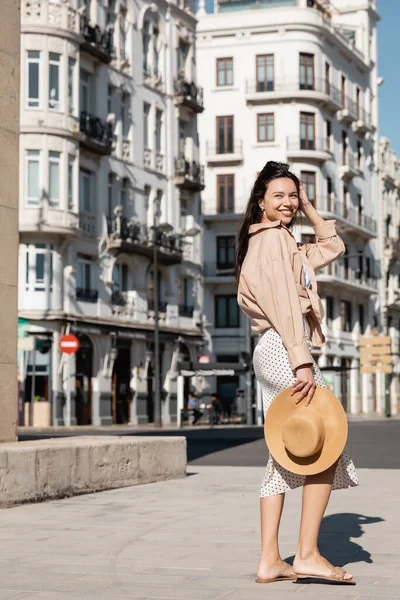 Full Length Happy Woman Trendy Clothes Holding Straw Hat Urban — Stockfoto