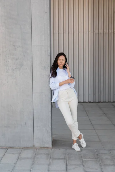 Full Length Woman White Pants Holding Paper Cup Talking Smartphone — 스톡 사진