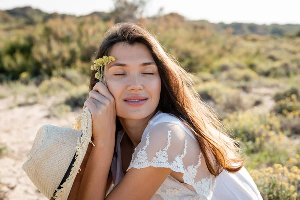 Mulher Sorridente Com Olhos Fechados Segurando Chapéu Sol Flores Gramado — Fotografia de Stock