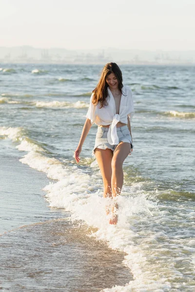 海の中で遊んでいる若い女性 — ストック写真