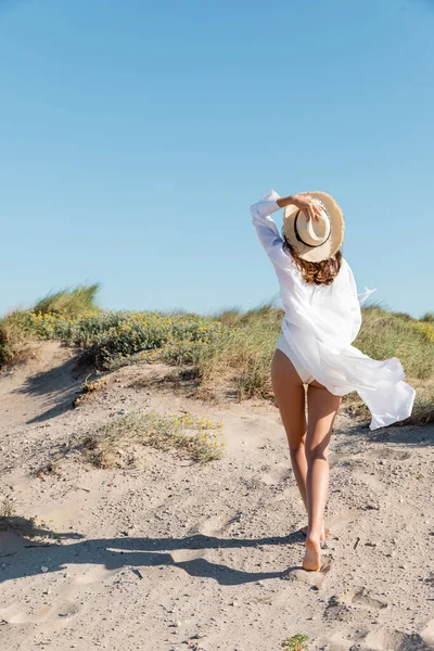수영복을 해변에서 모자를 맨발의 여성의 뒷모습 — 스톡 사진