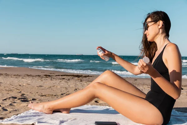 Fiatal Napszemüvegben Fekete Fürdőruha Alkalmazása Naptej Strandon — Stock Fotó