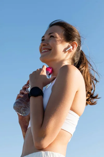 Visão Baixo Ângulo Mulher Feliz Garrafa Fone Ouvido Sem Fio — Fotografia de Stock