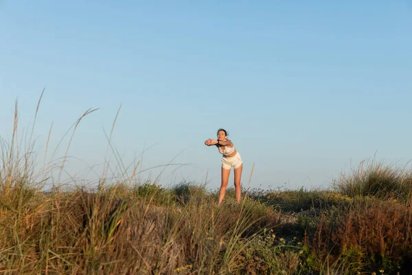 Young Woman Sportive Shorts Wireless Earphones Stretching — Stock Photo, Image