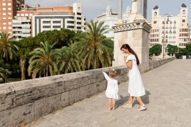 Valencia 'daki Puente Del Mar Köprüsü' nde parmak ucuyla annesini gösteren küçük kız.