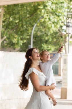 Annem Valencia 'da dudak parlatıcıyla bebeği tutarken başka tarafa bakıyor.