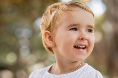 Portrait of happy baby girl looking away outdoors 