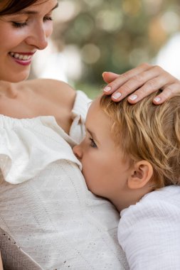Gülümseyen kadın dışarıda kızına dokunuyor. 
