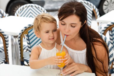 Anne İspanya 'da açık bir kafede kızının yanında portakal suyu içiyor. 