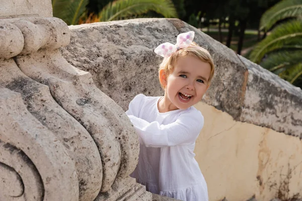 Cheerful Baby Girl Dress Looking Camera Stone Puente Del Mar — Zdjęcie stockowe