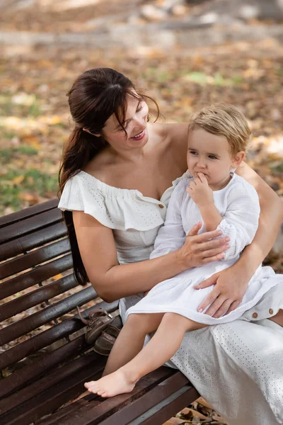 Smiling Woman Dress Hugging Toddler Daughter Bench Park — Photo