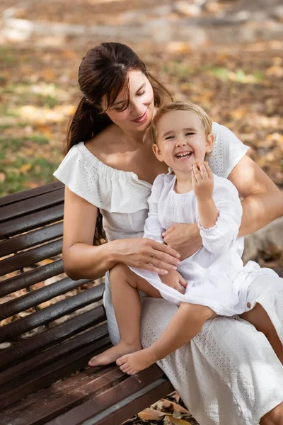 Cheerful Toddler Girl Holding Cookie While Sitting Mom Bench Summer — Photo