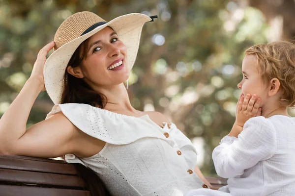 Donna Sorridente Cappello Sole Vestito Guardando Fotocamera Vicino Bambino Sulla — Foto Stock