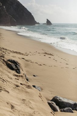 Portekiz 'de okyanus kıyısındaki ıslak kumlu Avrupa sahillerinde taşlar