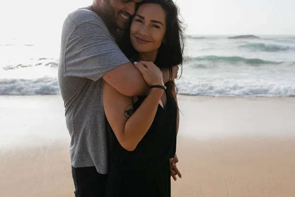 快乐的男人拥抱着快乐的 纹身的女友 穿着漂泊在大海边的衣服 — 图库照片