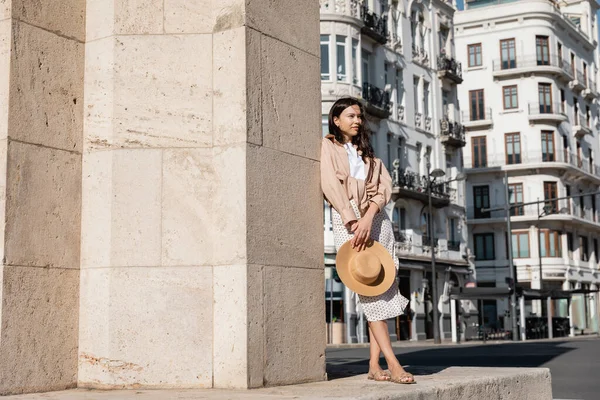 Visão comprimento total da mulher em roupas da moda de pé perto da parede na rua — Fotografia de Stock
