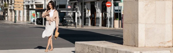 Pleine longueur de femme en vêtements à la mode marchant avec chapeau de paille sur la rue, bannière — Photo de stock