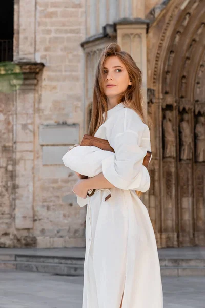 Jeune rousse femme en robe blanche tenant sac à main sur la rue de valencia — Photo de stock