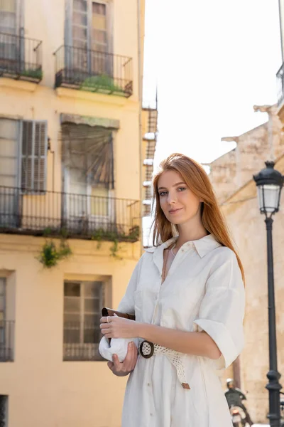 Sorrindo jovem mulher no vestido segurando bolsa na rua de valência — Fotografia de Stock