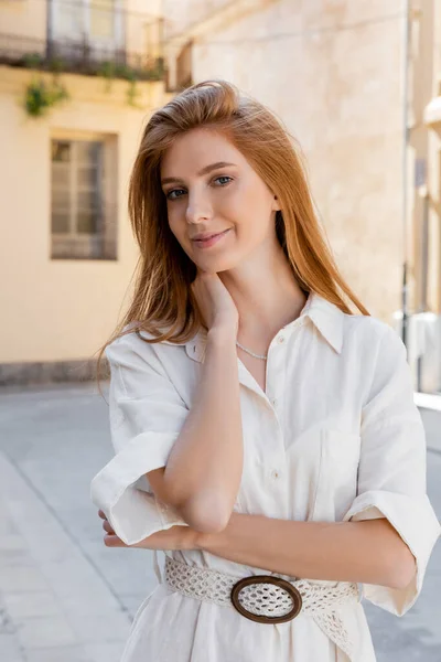 Portrait de femme souriante aux cheveux roux debout en robe blanche sur la rue de valencia — Photo de stock