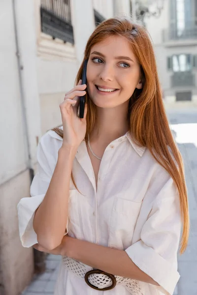 Portrait of cheerful and redhead woman talking on mobile phone in valencia — Stock Photo