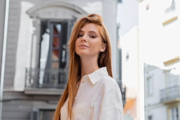Junge Frau mit roten Haaren blickt in die Kamera auf der europäischen Straße in Valencia — Stockfoto