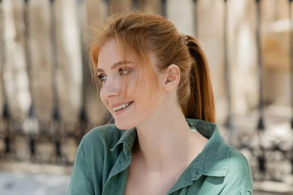 Retrato de feliz jovem mulher com cabelo vermelho e camisa de linho verde sorrindo fora — Fotografia de Stock