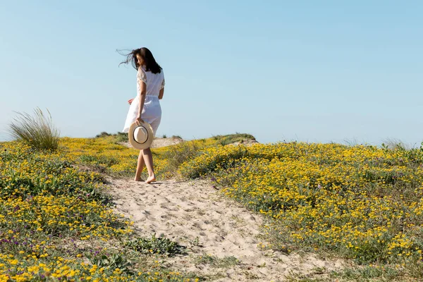 Brünette Frau mit Sonnenhut am Strand — Stockfoto