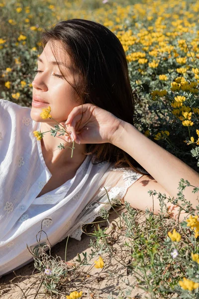 Portrait of young woman holding flower on meadow — Stock Photo